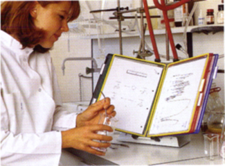 Woman in laboratory using a Tarifold desktop organizer to review chemical formulas.